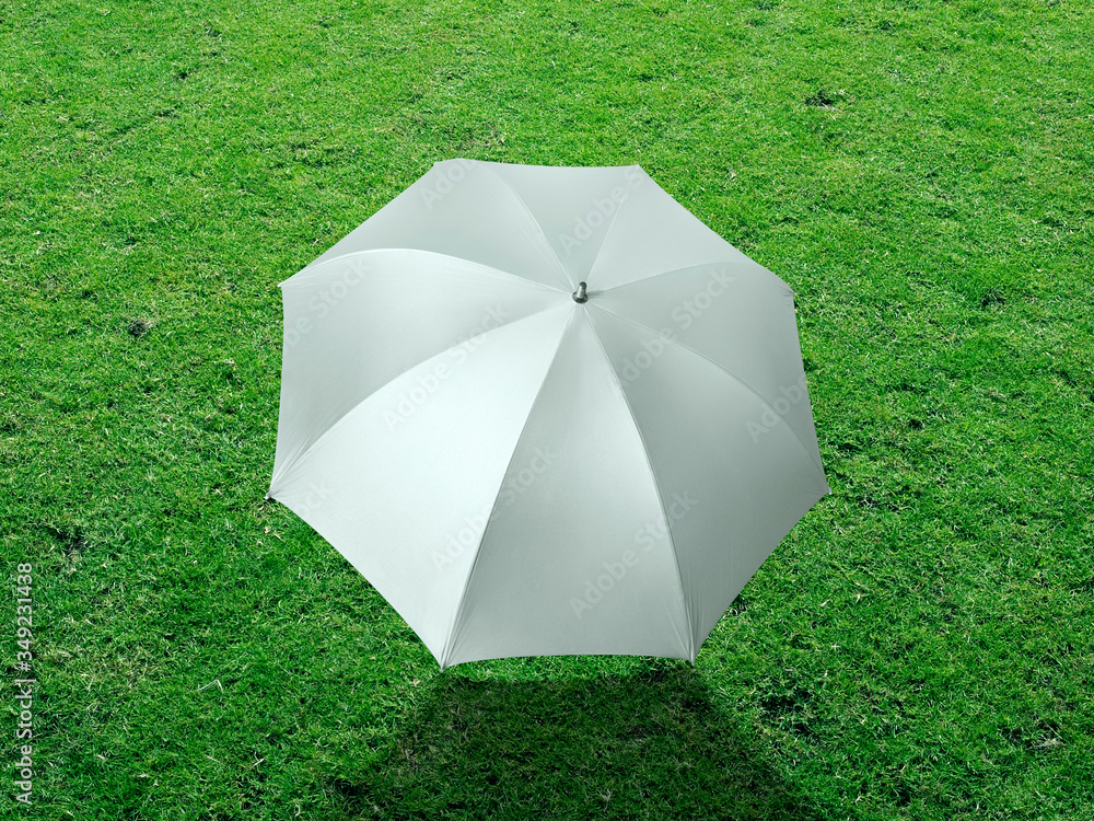 The white sun umbrella place on green grass golf course using for sun protection