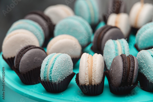 Light cream, tiffany blue and chocolate macaroons on tiffany blue stand. Food knolling concept