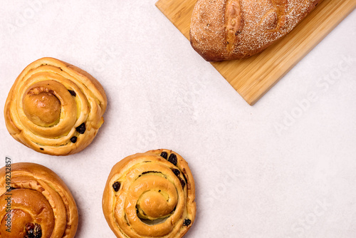 Freshly Baked Buns with Raisins and Cinnamon on Light Gray Background Top view Sweet Homemade Pastry Swedish Dessert Copy Spaace photo