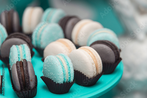 Obraz na plátně Light cream, tiffany blue and chocolate macaroons on tiffany blue stand