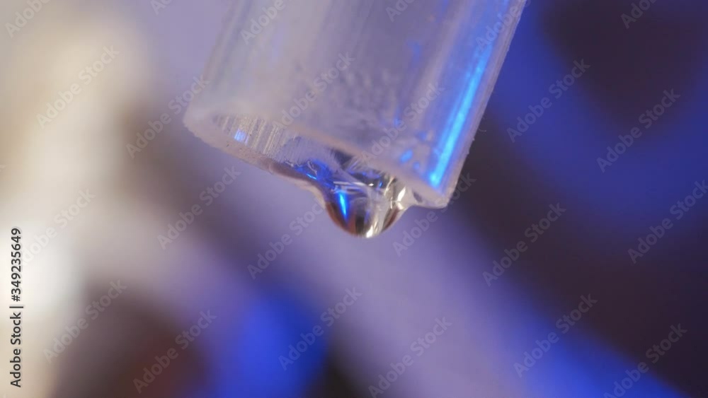 close-up of drops of moonshine dripping from a silicone tube close-up of drops of moonshine dripping from a silicone tube