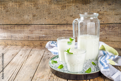 Cold Indian drink Lassi, iced coconut Lassi drink with mint leaf, wooden background copy space photo