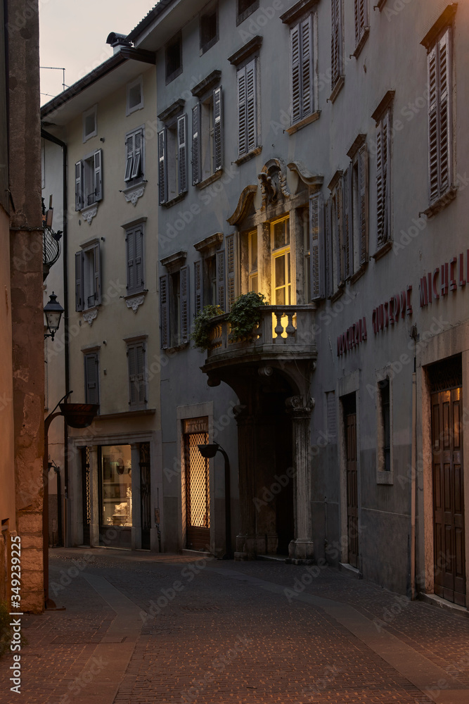 Italian cityscape evening mysterious narrow empty street by night. Night view of the Rovereto city