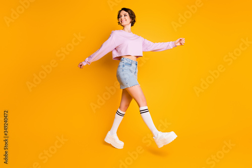 Full body profile side photo of energetic girl have summer rest relax go walk weekend free time promenade wear pullover sneakers isolated over bright color background © deagreez