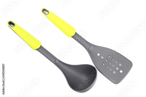 Grey plastic kitchen spatula and ladle with light green inserts isolated on white