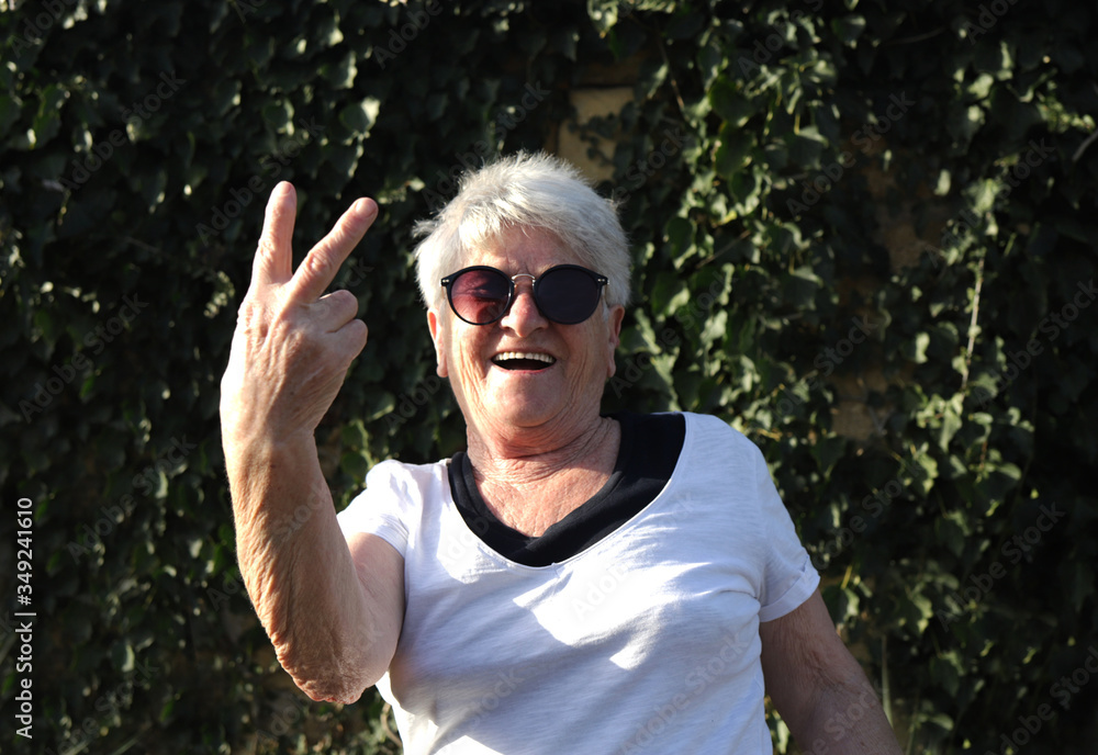 Closeup portrait of an old woman in sunglasses on the nature. The concept of health and longevity. Closeup portrait of an old woman in sunglasses on the nature. The concept of health and longevity.