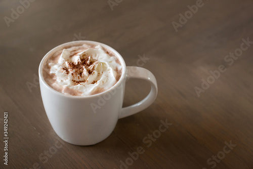 Hot chocolate cocoa with whipped cream on wooden background