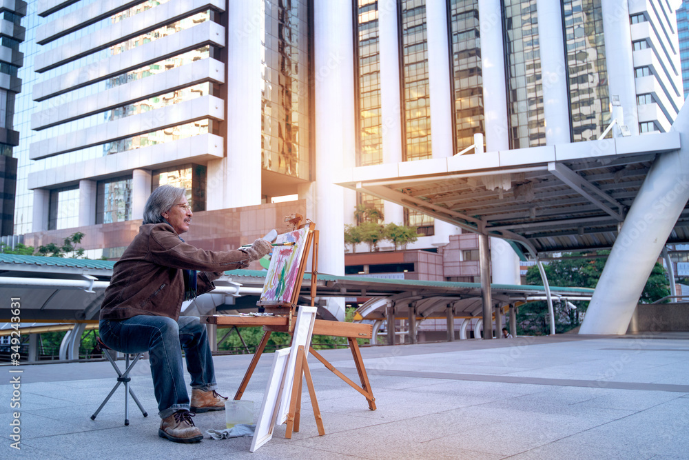 Asian street artist paints a picture in the city Asian street artist paints a picture in the city