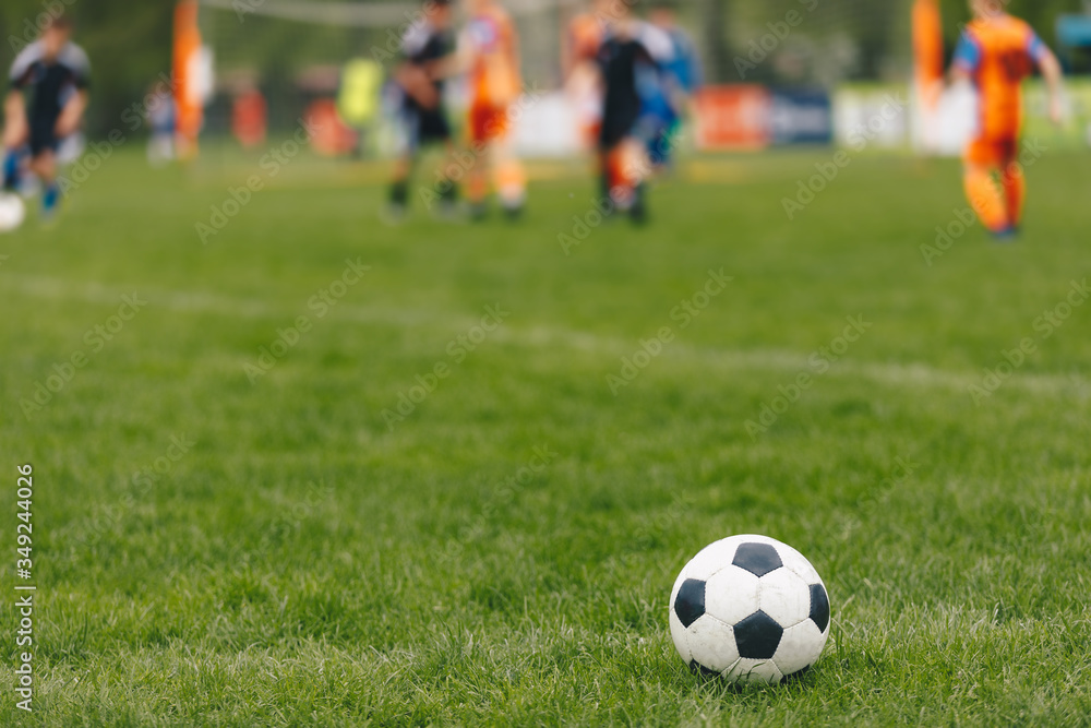 Sports outdoor background. Soccer ball on the field. Football competition tournament match in the blurred background. Sports arena stadium in summer time