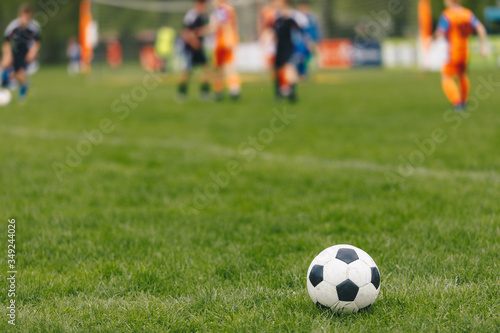 Sports outdoor background. Soccer ball on the field. Football competition tournament match in the blurred background. Sports arena stadium in summer time