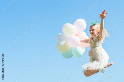 Happy jumping girl with colorful balloons, Summertime fun