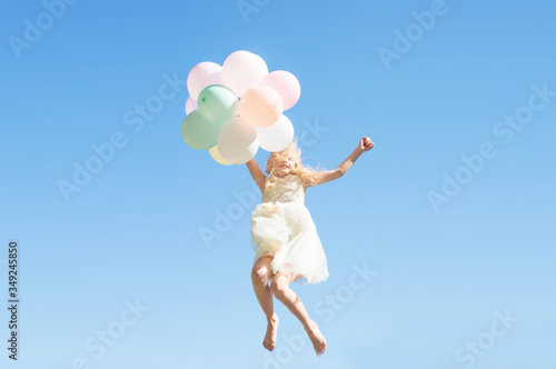 Happy jumping girl with colorful balloons, Summertime fun