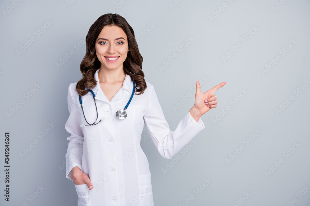Wash your hands regularly. Photo of beautiful family doc lady assistant virology clinic direct finger empty space show banner rules safety wear lab coat isolated grey color background Wash your hands regularly. Photo of beautiful family doc lady assistant virology clinic direct finger empty space show banner rules safety wear lab coat isolated grey color background