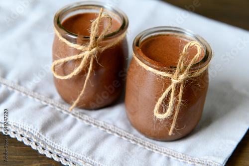 Chocolate mousse in small jars on a wooden background. Selective focus.