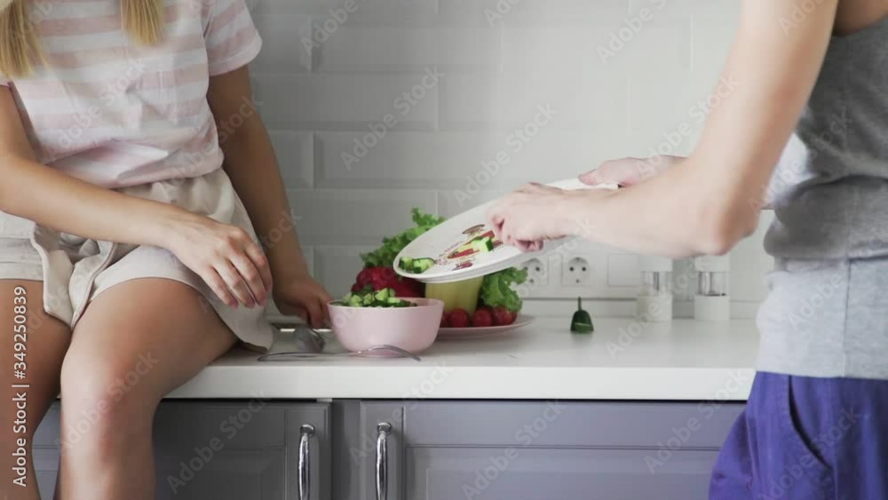 Loving couple cutting vegetables together, add spices in salad for lunch in the kitchen Loving couple cutting vegetables together, add spices in salad for lunch in the kitchen