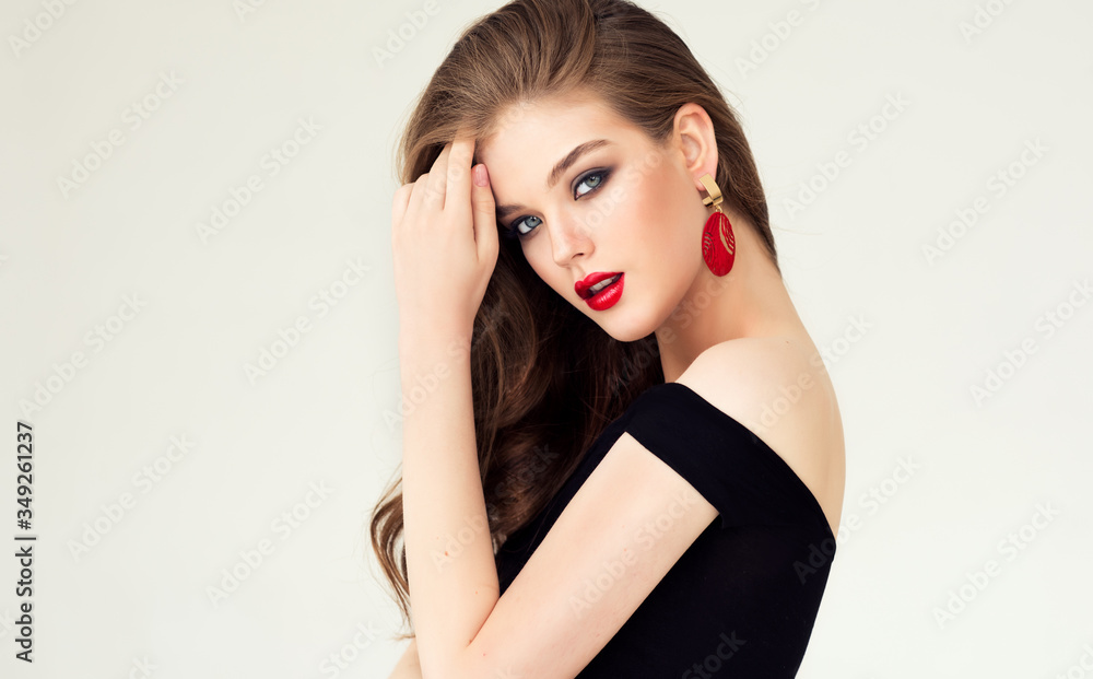 Obraz premium Beautiful model girl with elegant hairstyle . Woman with red lips and earrings . Cosmetics, beauty and jewelry accessories 