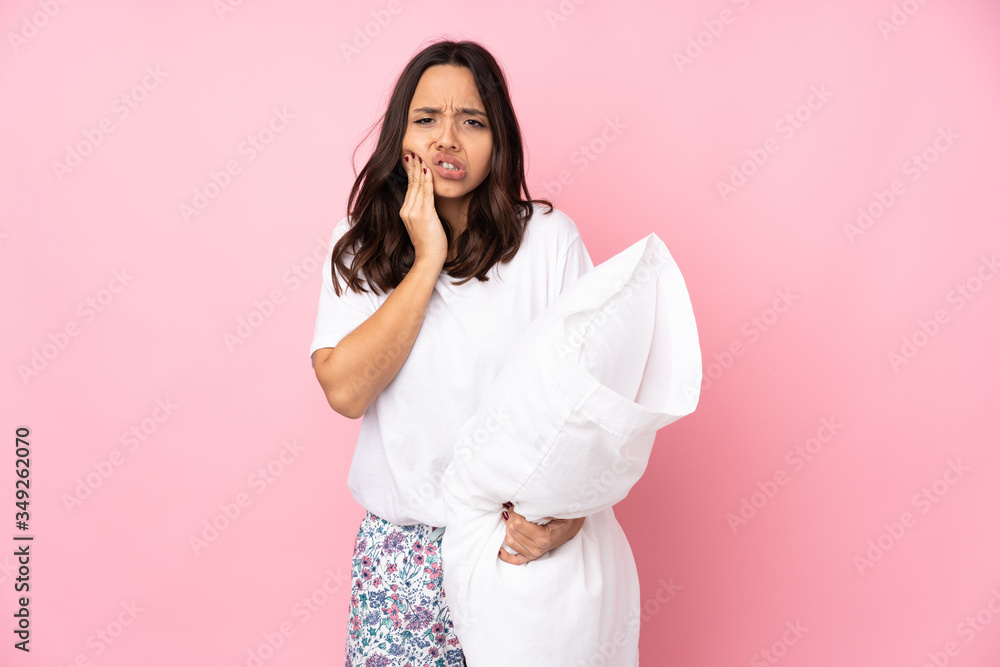 Young woman in pajamas isolated on pink background with toothache Young woman in pajamas isolated on pink background with toothache