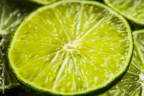 Colorful background with thin lime slices. Selective focus. Shallow depth of field.