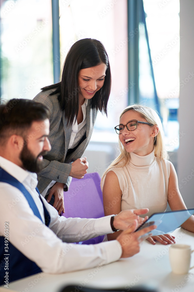 Office colleagues smiling while discussing business Office colleagues smiling while discussing business