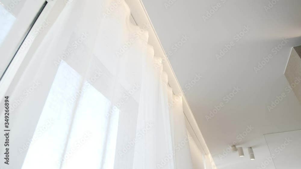 Upward Shot along Modern White Curtains in a Room with Large Windows Upward Shot along Modern White Curtains in a Room with Large Windows