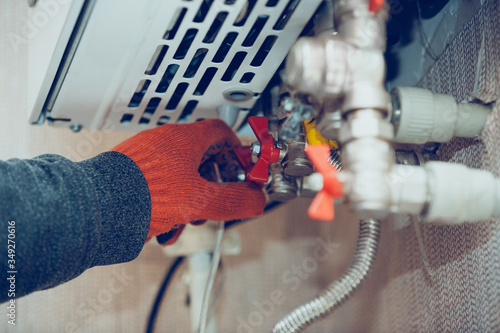 Tableau sur toile Close up of male hand closes the wick of a gas bottle, home heater, shuts off the flow