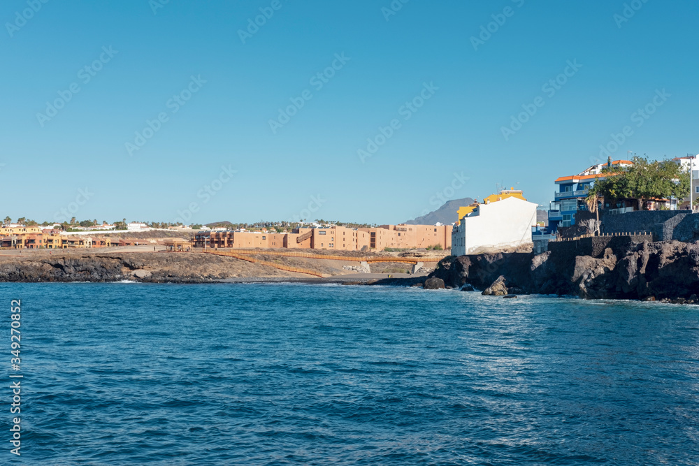 View from the picturesque fishing harbor towards seafront restaurants, houses and a small beach known as Playa Grande, Los Abrigos, Granadilla de Abona, Tenerife, Canary Islands, Spain