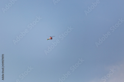 Helicopter painted in the colors of the italian flag flying in the blue sky