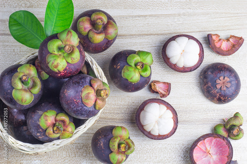Mangosteen and cross section showing the thick purple skin and white flesh of the queen of friuts, Delicious mangosteen fruit arranged on a bowl, Mangosteen flesh, closeup. Mangosteen.
