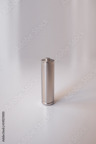 A gray AA model battery stands upright on a white background