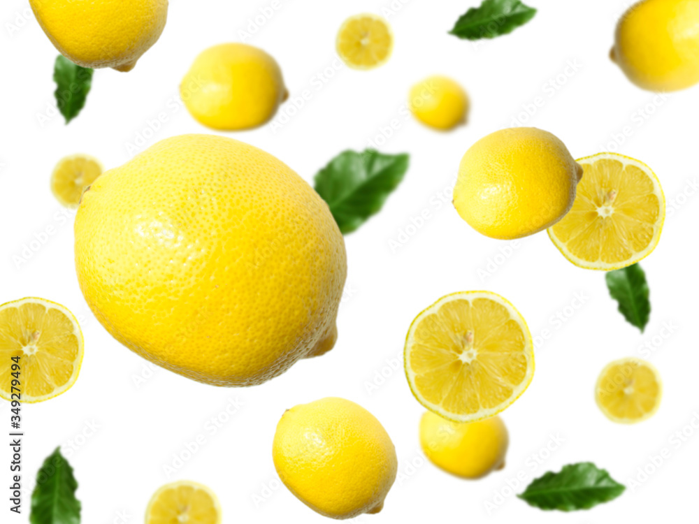 Levitation of a whole lemon and slices with green leaves on a light background. Image with selective focus.