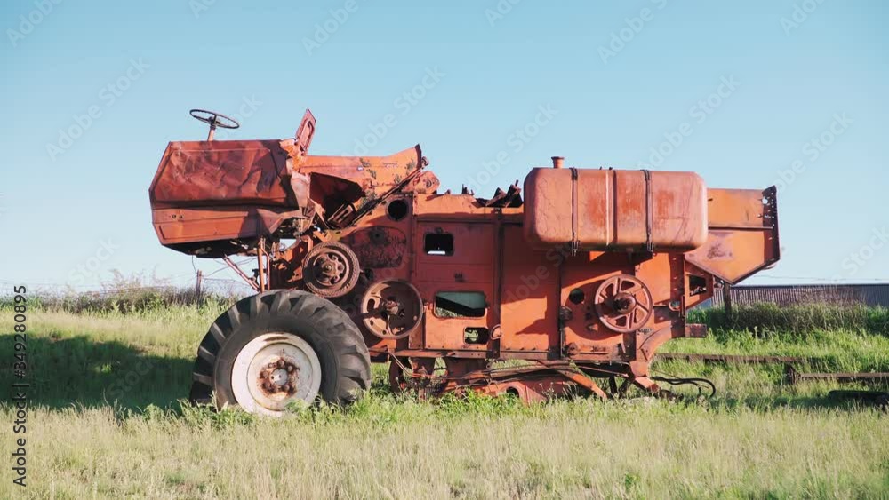 Old rusted tractor aged on farm land. Abandoned agricultural machinery Old rusted tractor aged on farm land. Abandoned agricultural machinery
