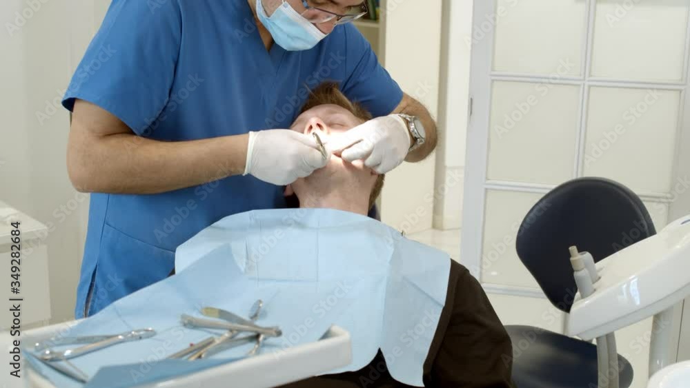 Dental clinic. Doctor dentist treats teeth to the patient in the dental clinic. Dentistry and orthodontist. Dental treatment and bite correction. Dental clinic. Doctor dentist treats teeth to the patient in the dental clinic. Dentistry and orthodontist. Dental treatment and bite correction.