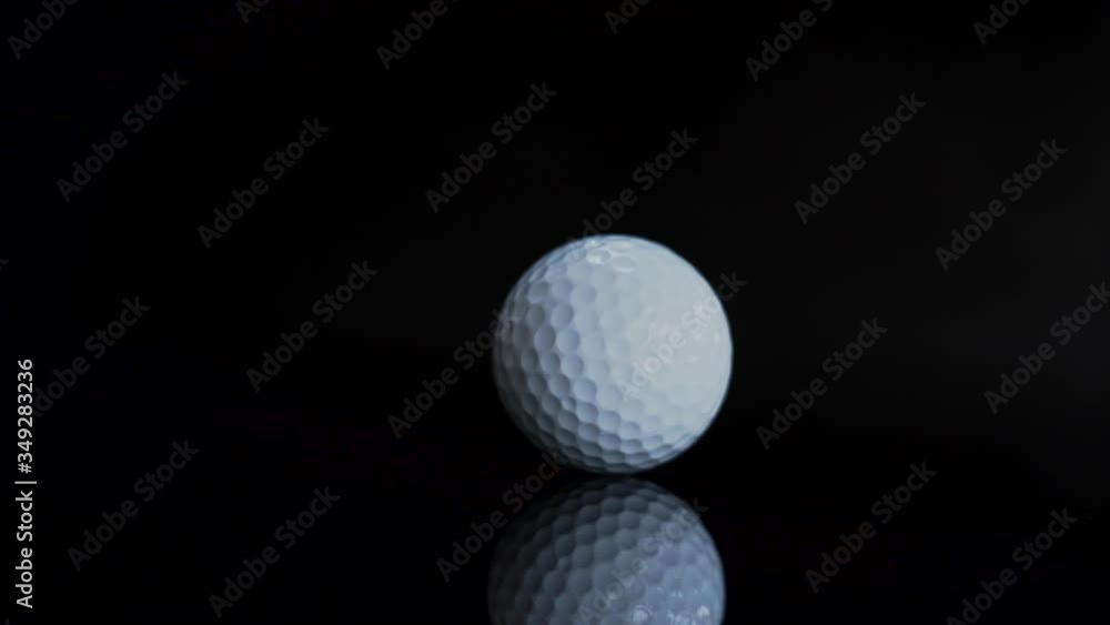 Golf ball white color turn rotating on black background with reflection. Golf ball white color turn rotating on black background with reflection.