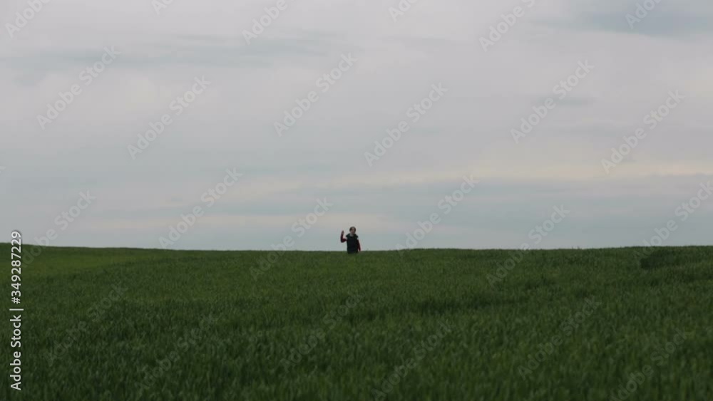 Preteen children, boys, running in green field on a cloudy day, childhood happiness Preteen children, boys, running in green field on a cloudy day, childhood happiness