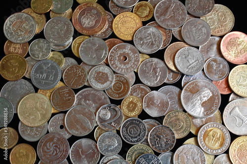Scattering of coins from different countries and continents. Background image. Coins of the USA, Thailand, Switzerland, Tunisia, Czech Republic, United Arab Emirates, Egypt, Croatia, Turkey and others
