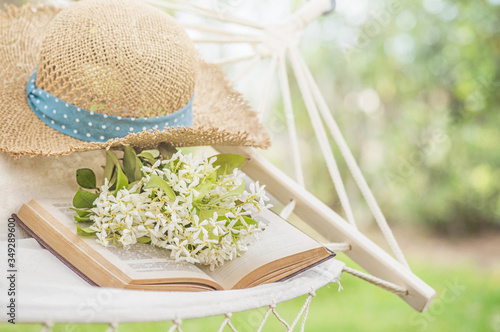 Fototapeta Naklejka Na Ścianę i Meble -  Straw hat on a hammock in a sunny summer day. Rest in the garden. Summer time fun