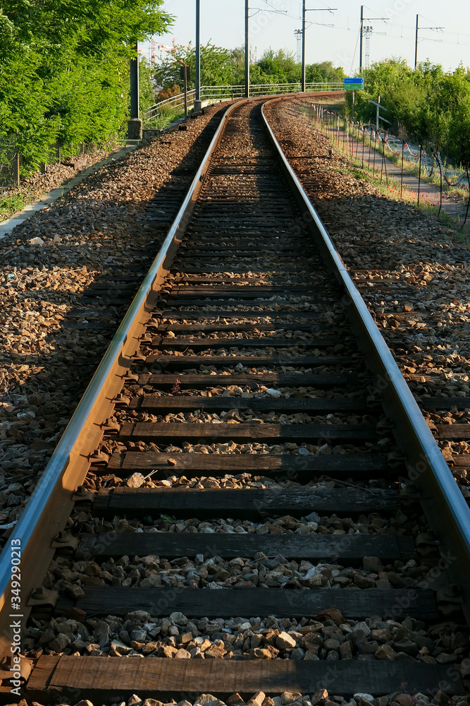 Perspective on railway tracks. Vegetation in the background.