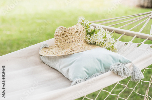 Straw hat on a hammock in a sunny summer day. Rest in the garden. Summer time fun