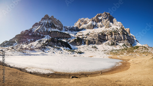 Frozen lake and snowy mountain on a sunny winter day, spanish pyrenees, Spain photo