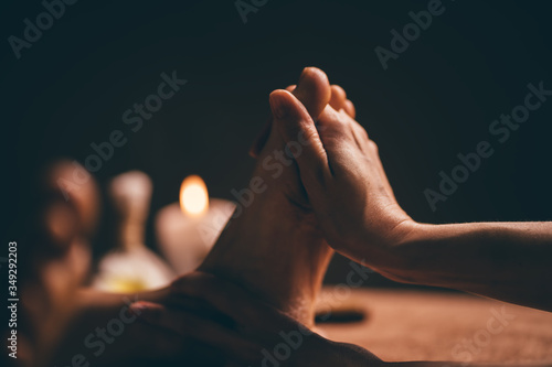 Professional foot massage close up. Authentic shot of luxury spa treatment. Charming light. Shallow depth of field. Stylized and colored. Copy space © gudenkoa