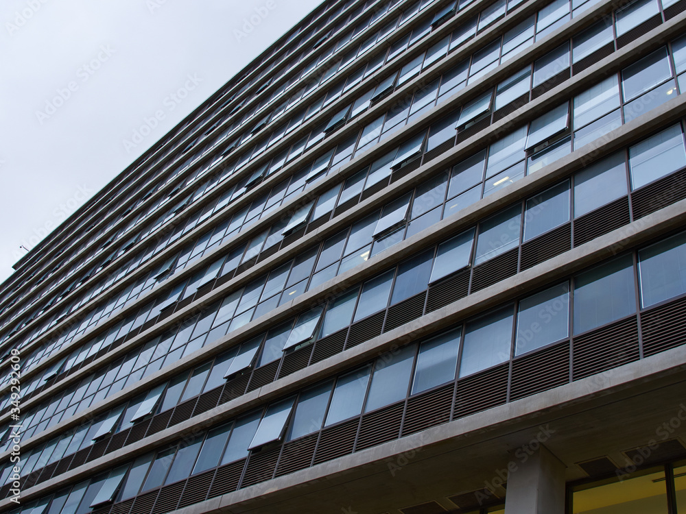 Low angle vView from the bottom of an office building with glass windows Low angle vView from the bottom of an office building with glass windows