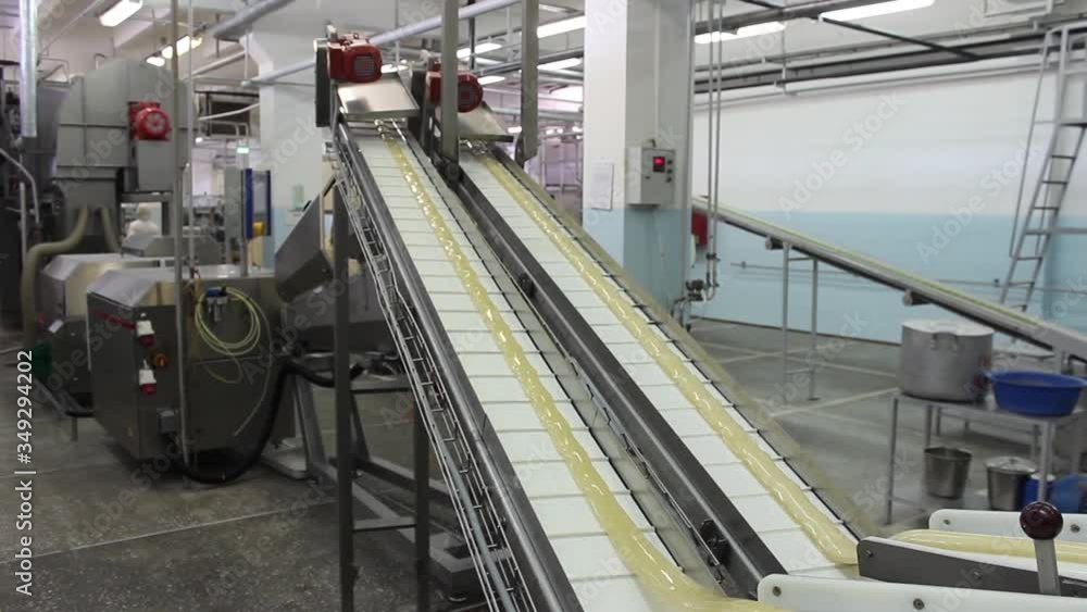 An infinitely long caramel billet moves on a conveyor belt in a confectionery factory. An infinitely long caramel billet moves on a conveyor belt in a confectionery factory.