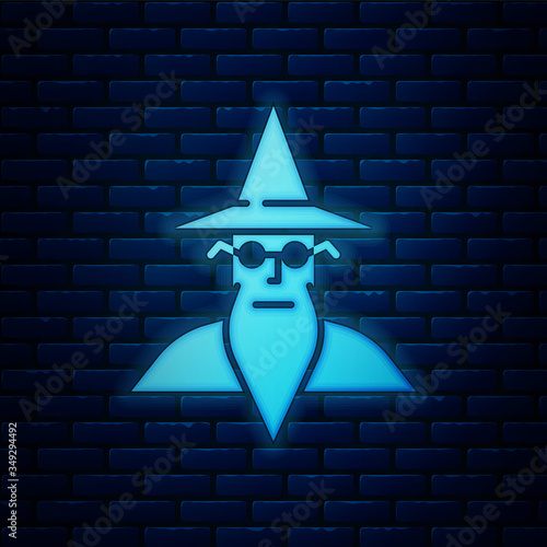 Glowing neon Wizard warlock icon isolated on brick wall background. Vector Illustration