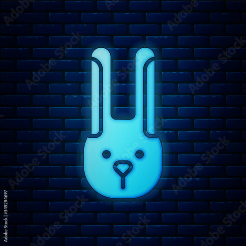 Glowing neon Rabbit with ears icon isolated on brick wall background. Magic trick. Mystery entertainment concept. Vector Illustration