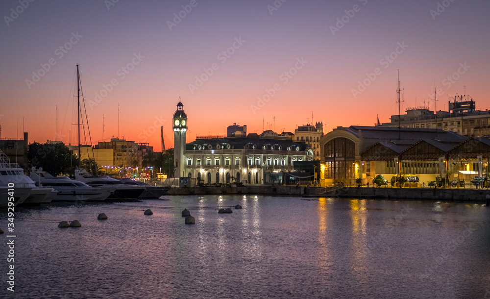 Valencia harbor, Sunset marina port Spanish city nautical scene warm red colors. Port Authority buildings with clock tower