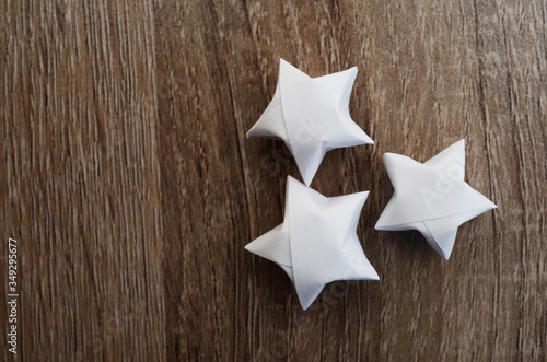 three white origami lucky stars on wooden