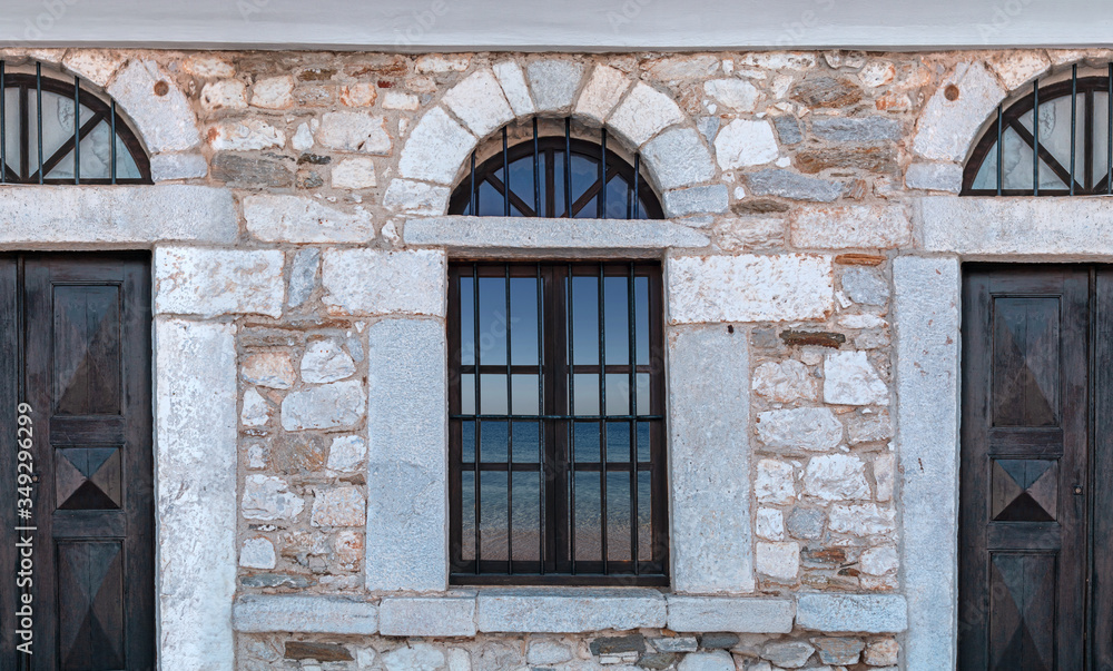 Obraz premium Old architecture stone house with blue sea reflection on windows