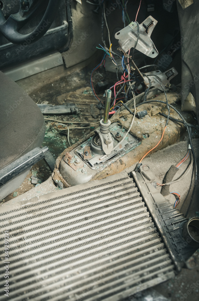 Fototapeta premium inside vertical view to gear shifter and wires of a broken and disassembled interior of old abandoned car at dump