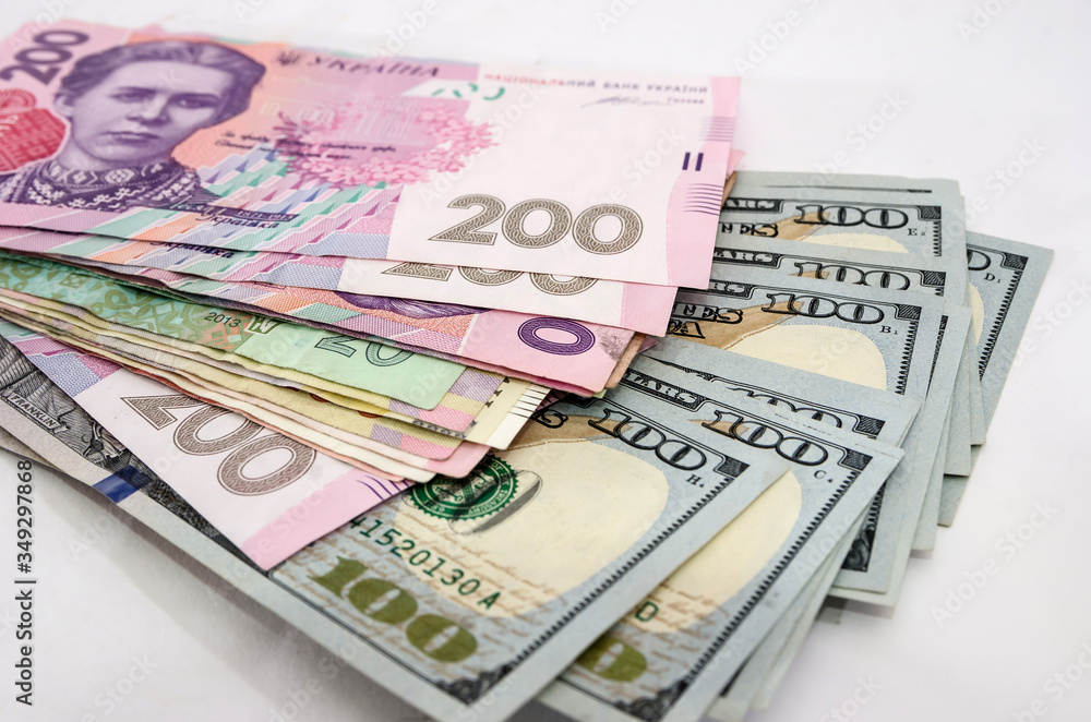 Dollars and different hryvnias on white. Business concept. Dollars and different hryvnias on white. Business concept.