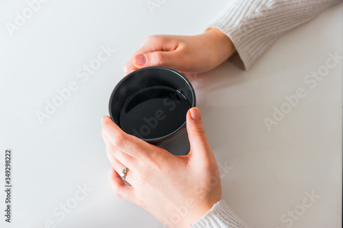 Young girl holding a cup of hot coffee. 